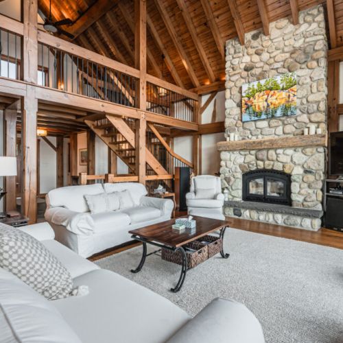 Experience the warmth of rustic charm in our open-concept living space, featuring high vaulted ceilings and a seamless blend of natural wood and stone accents.