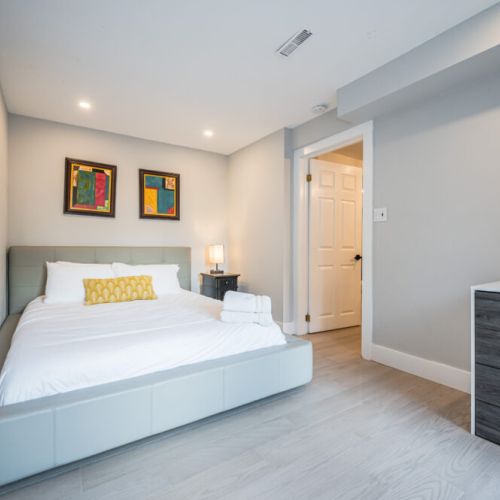 Guest suite, lower level decorated in a post-modern vibe, with a dresser that has a modern touch, providing ample storage in a clean, contemporary design..