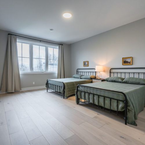 Enter the inviting guest room where two luxurious queen-sized beds take center stage, promising a restful night's sleep in plush comfort. The room is thoughtfully designed to accommodate friends, family, or couples with ample sleeping space.