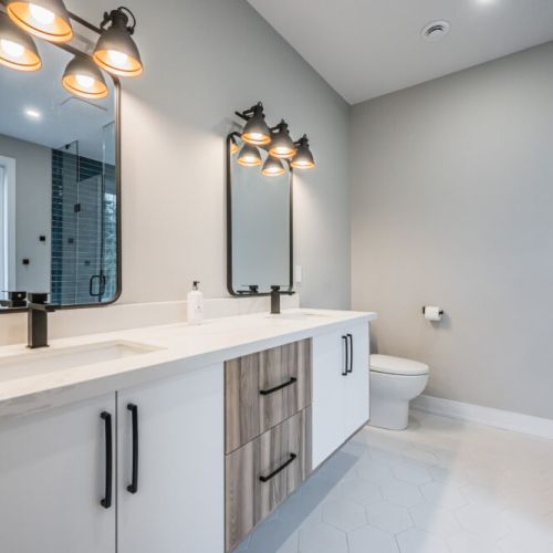 Enhancing functionality and convenience, the ensuite bathroom features double sinks placed side by side. This thoughtful design allows ample space for couples or guests to share the morning routine without compromise.