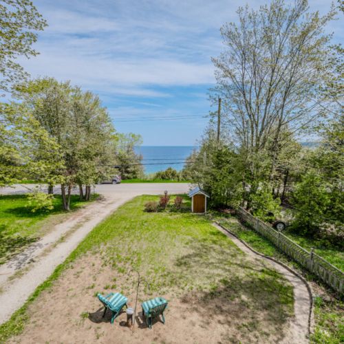 Beeshore welcomes you with a picturesque front yard, inviting you into a serene cottaging experience.