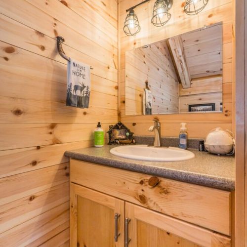 he loft features a charming half-bathroom with rustic decor, providing convenience and comfort for guests staying in the upstairs bedrooms.