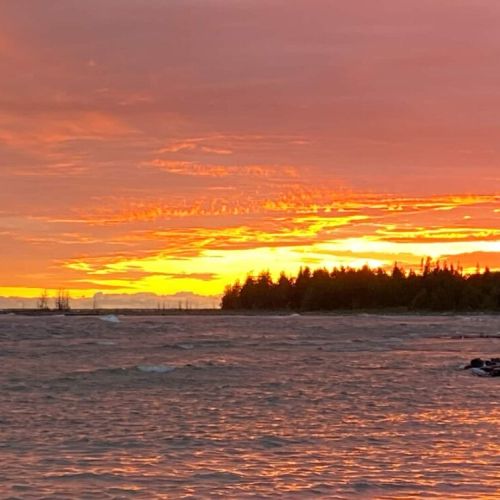 Witness breathtaking Lake Huron sunsets with vibrant skies and tranquil waters—ideal for your next lakeside getaway.