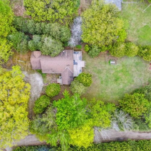 Aerial perspective reveals the spacious, private lot—perfectly nestled among the trees with direct lake access and lots of room to explore.