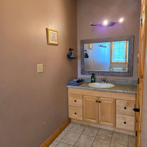 Spacious bathroom with rustic cabinetry and bright lighting—ideal for refreshing after a day exploring nature or relaxing by the fire.