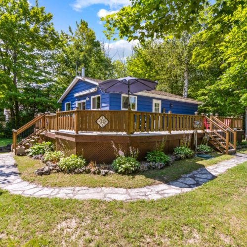 Relax on the spacious wraparound deck surrounded by mature trees.