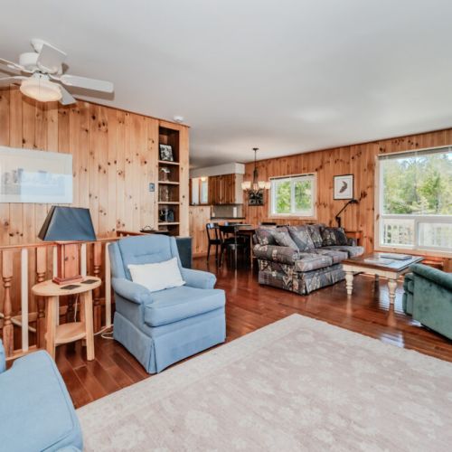 Cozy, rustic living space featuring wood accents, comfy seating, and a charming cottage vibe — perfect for lakeside family getaways.