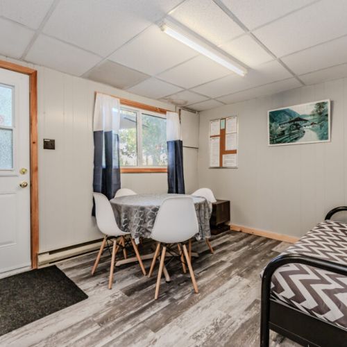A comfortable living space with a table and chairs, suitable for meals or playing games, alongside cozy seating for relaxation.