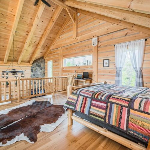 Second bedroom with queen sized bed and work area. The loft's open space includes a serene reading and games lounge, a dedicated work area overlooking the great room, and cozy semi-private bedrooms, all designed to cater to moments of inspiration or