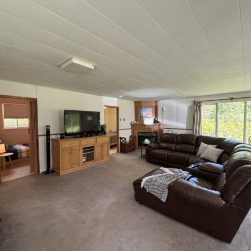 Relax with a movie night in this large living space featuring a flat-screen TV, sound system, and plush seating—great for rainy-day retreats.