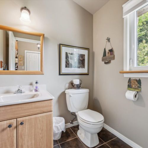Charming second bathroom with natural light and cottage-themed decor to complete your stay.