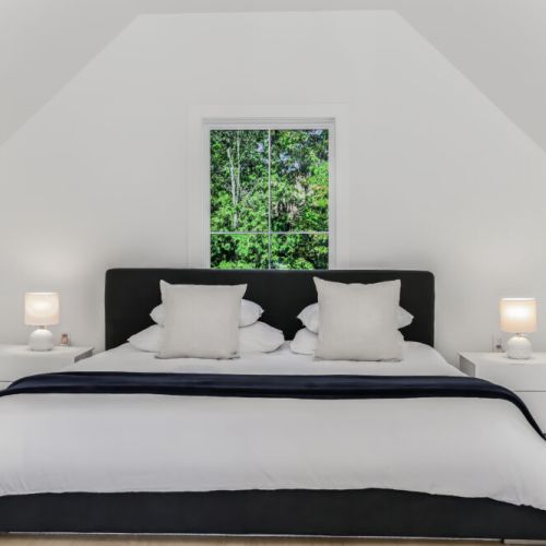 Cozy loft sleeping space with a comfy bed and bright forest views.