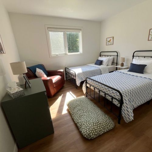 Bedroom 3: Third bedroom featuring two comfortable twin beds, perfect for children, friends, or additional guests. Bright natural light and cozy furnishings create a welcoming space for a restful night's sleep.