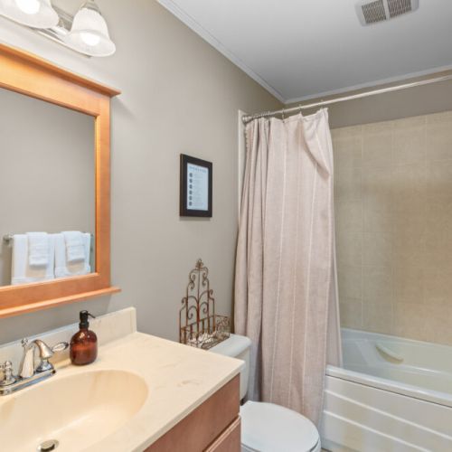 This full bathroom features a tub and shower combination, making it convenient for guests of all ages.
