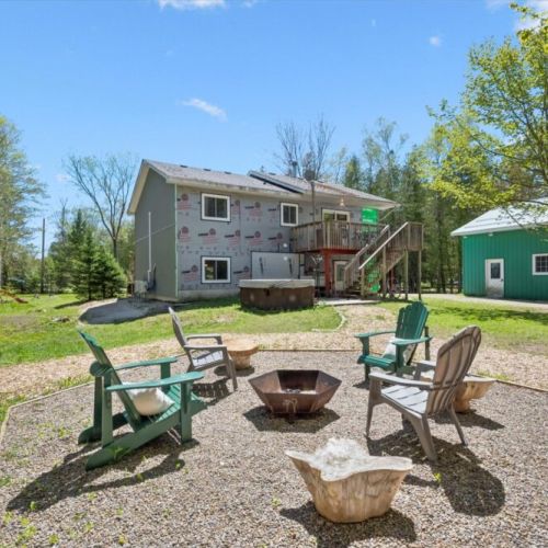 Gather around the firepit with comfortable Muskoka chairs nestled in a quiet forest setting.