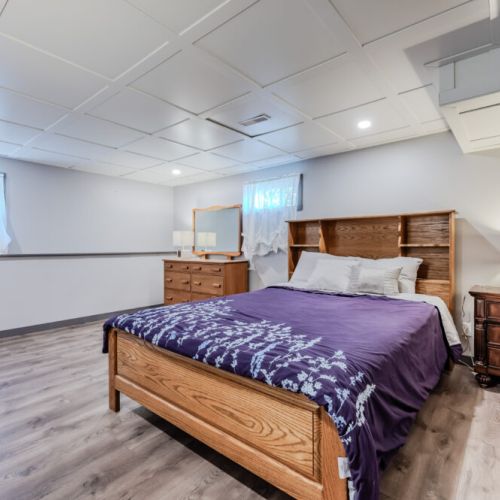 Cozy and spacious bedroom with warm wood furnishings and soft lighting—perfect for a restful night after lakeside adventures. Ideal for couples or solo travelers enjoying a peaceful vacation retreat.