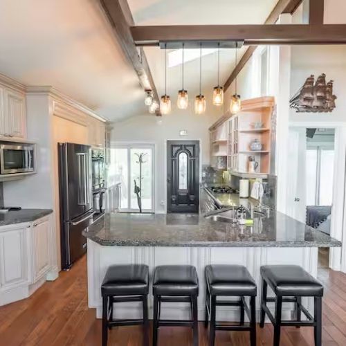 The heart of the home — a stunning chef’s kitchen with granite countertops, high-end appliances, and a breakfast bar with seating for four.