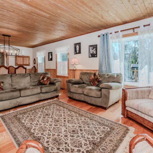 Charming open layout with warm wood finishes and forest views, offering a cozy retreat for your next country vacation.
