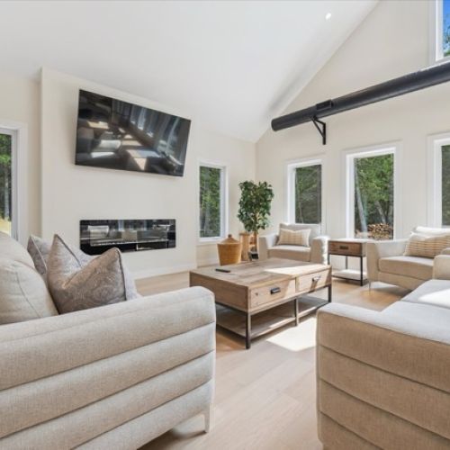 Bathed in natural light, this airy living room features vaulted ceilings, a sleek fireplace, and plush seating — perfect for cozy nights in or relaxing after outdoor adventures.