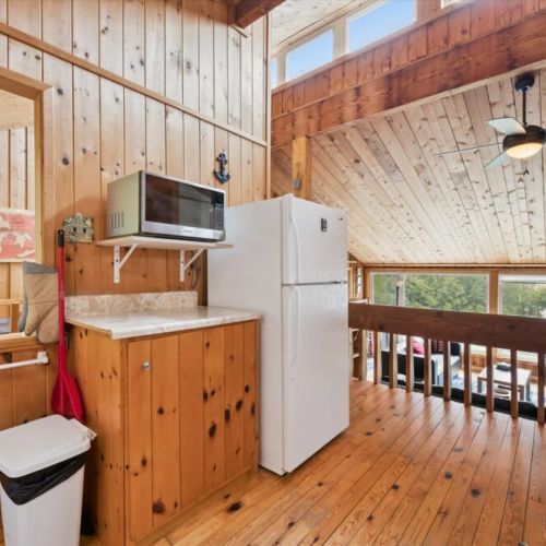 The open layout connects the kitchen to the cottage living space, creating a warm and inviting atmosphere for your stay.