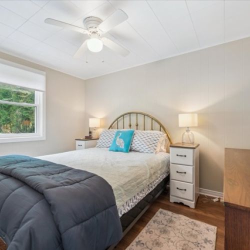 Inviting bedroom with a comfortable bed, soft lighting, and a large mirror for a spacious feel.