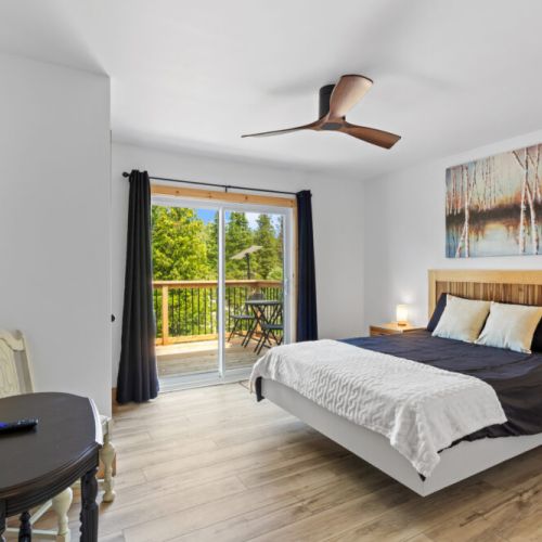 The spacious primary bedroom features a comfortable bed and private balcony access.