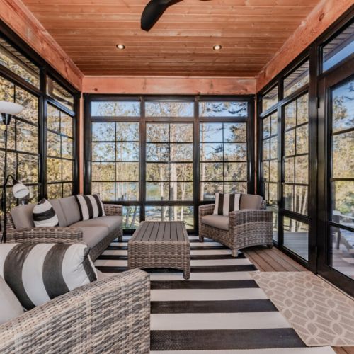 This bright and breezy sunroom with modern rustic charm offers stunning lake views, ideal for vacationers seeking both comfort and nature.