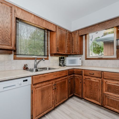 Enjoy a fully equipped, classic cottage kitchen with wood cabinetry, ideal for cooking memorable meals during your lakeside escape.