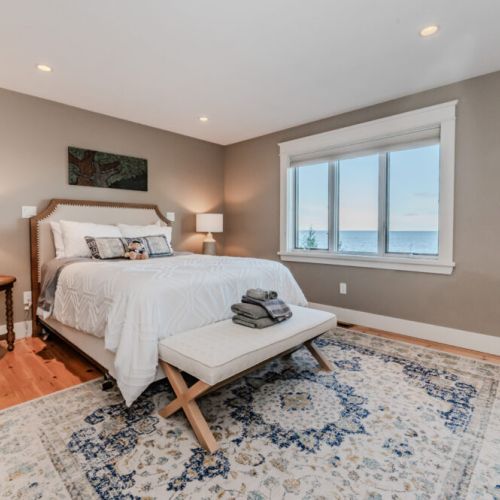 Cozy bedroom with a stunning lake view, warm lighting, and soft decor—perfect for a peaceful retreat. (Queen Bed)