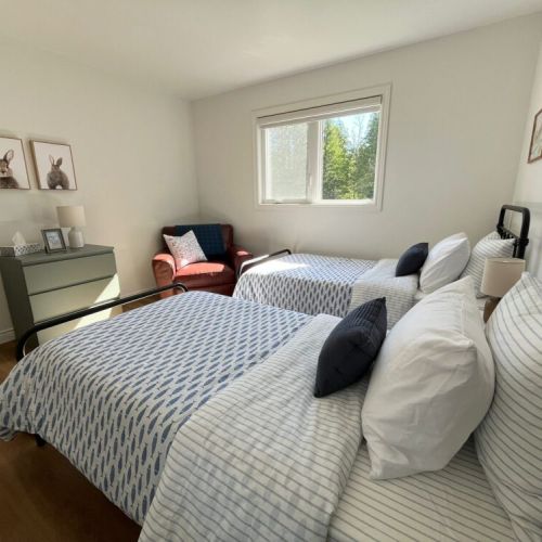 Bedroom 3: The third bedroom offers two twin beds, a comfortable reading chair, and plenty of natural light, making it an ideal retreat for extra guests or younger travelers.