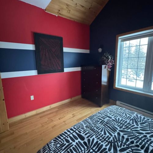 Modern flair meets rustic warmth in this colourful, artful bedroom—perfect for stylish travelers looking for a cozy space to unwind.