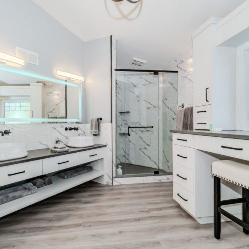 Spacious ensuite with dual sinks, LED mirror, walk-in glass shower, and a vanity area—experience true luxury on your vacation.