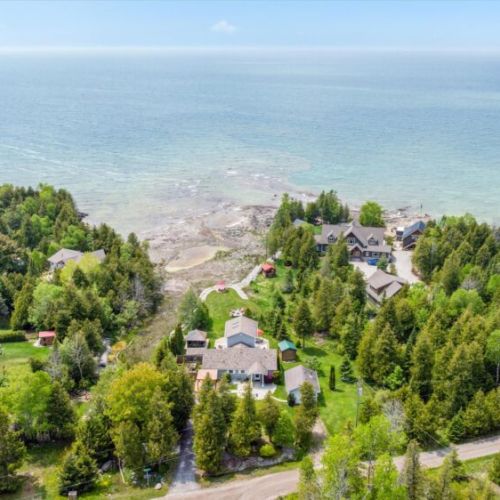 An expansive aerial view shows how Heaven on Earth is perfectly tucked along the shoreline of Lake Huron, offering direct water access, beautiful privacy, and a tranquil setting — all just steps from your door.