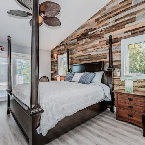 Rustic-chic bedroom with private balcony access and nature views—unwind in comfort during your perfect cabin vacation stay.