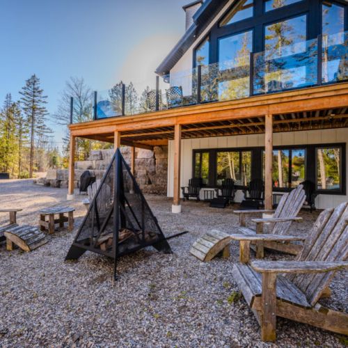 Soak up the outdoors at this modern vacation rental featuring a cozy fire pit, rustic Adirondack chairs, and a spacious deck—perfect for nature retreats, group getaways, and evening relaxation in the heart of cottage country.