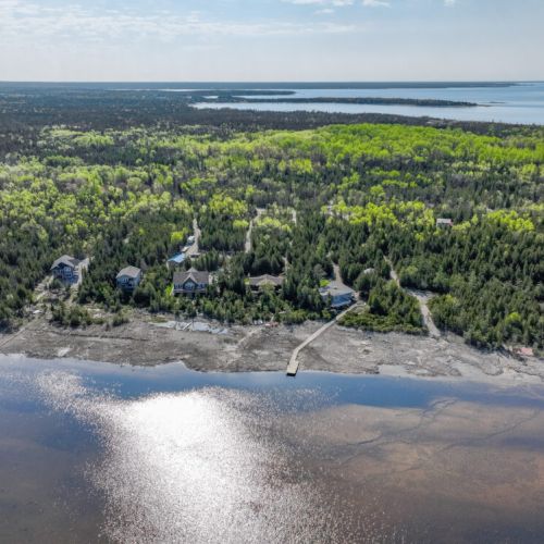 Discover the natural splendor that envelops your cottage, with an aerial view showcasing the dense forest and pristine landscapes that make this location a true escape into nature.