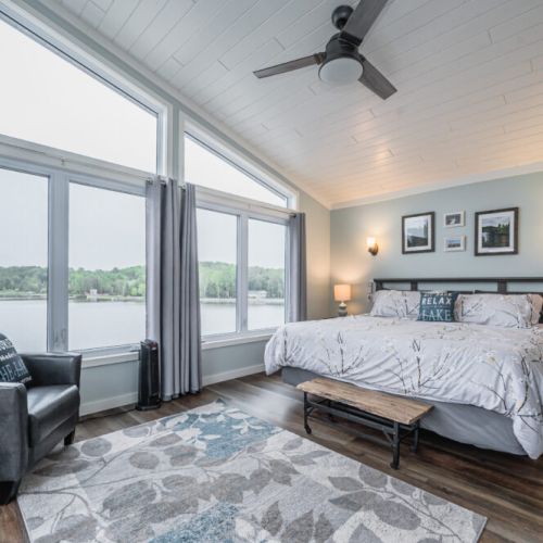 Bedroom 1: Primary bedroom retreat with stunning panoramic water views and cozy seating.