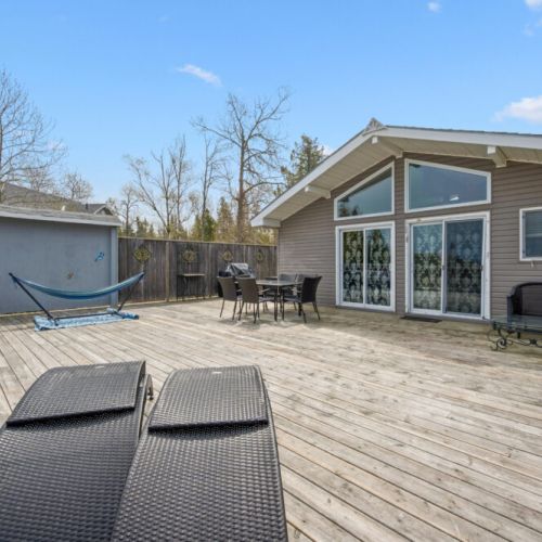 Spacious lakeside deck featuring comfortable loungers and plenty of room to relax outdoors.