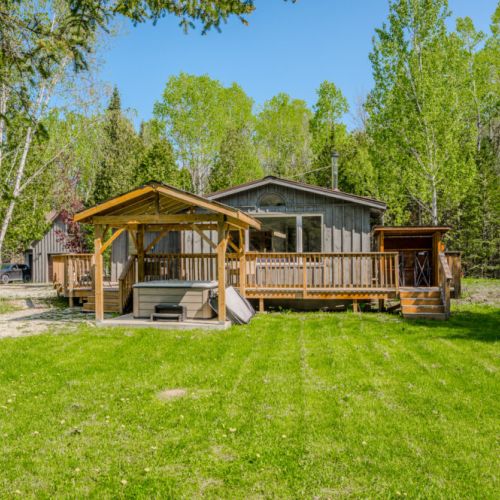 Unwind under the robust wooden gazebo, an idyllic spot for an evening soak in the hot tub, with nature's canopy surrounding you.