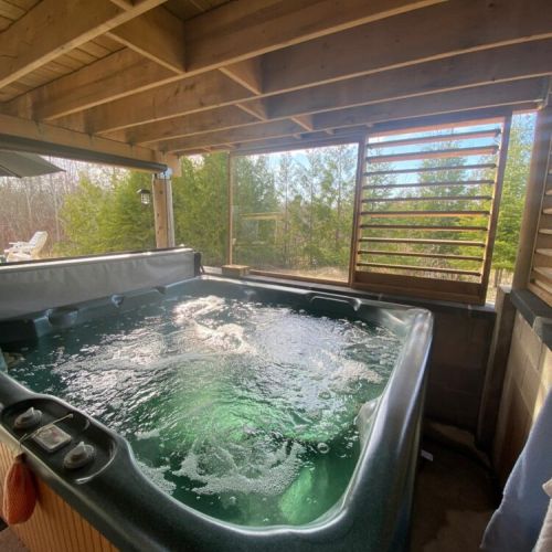 Unwind in the private 6-person hot tub surrounded by peaceful forest views.