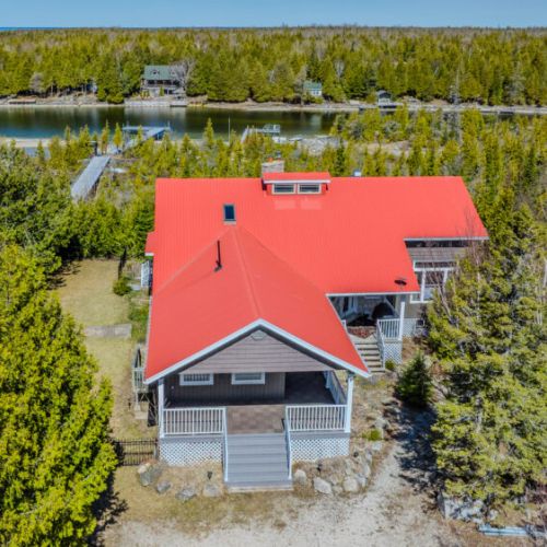 Charming waterfront cottage with bold red roof, direct lake access, and peaceful forest setting. Perfect for relaxing getaways, fishing trips, and family adventures.