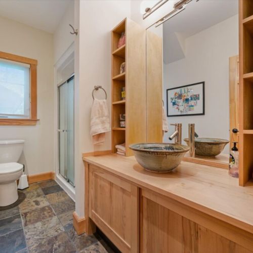 Spacious bathroom vanity area with rustic cottage-inspired finishes.