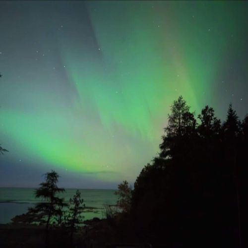 Catch the magical northern lights over the lake for an unforgettable stargazing experience at your private retreat.