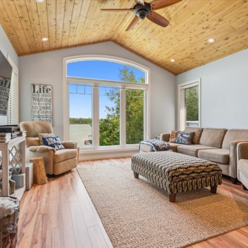 Bright and airy living space with vaulted wood ceiling and breathtaking lake views.