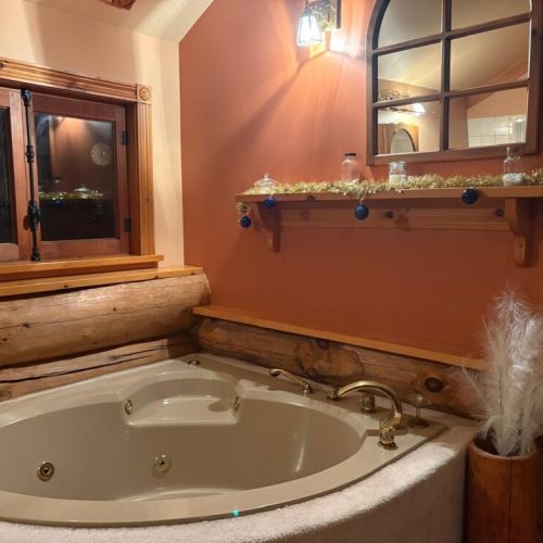 Unwind in the Timber Shores jacuzzi with warm lamplight and cozy holiday charm.