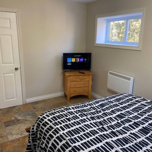 Relax after a day of adventure in this inviting bedroom with a comfortable bed and TV, ideal for your vacation stay.