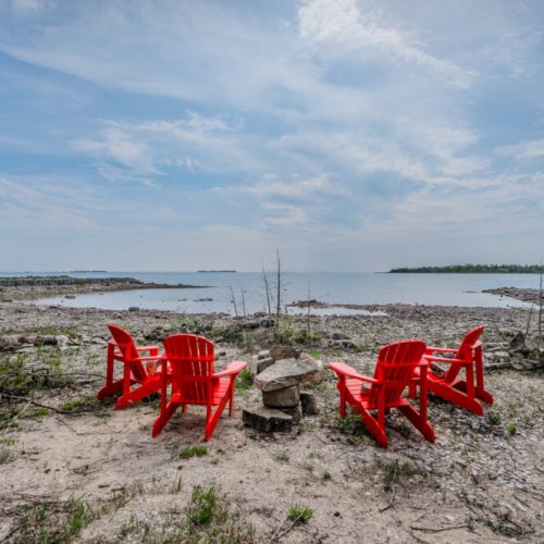 Gather around the lakeside firepit with Adirondack chairs and sweeping views of Lake Huron—perfect for stargazing or sunset chats.