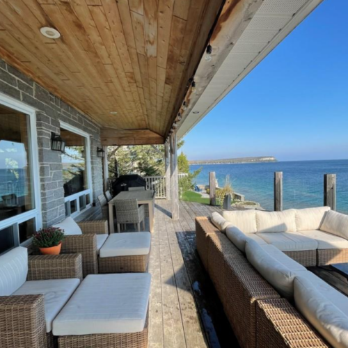 Relax on the comfortable outdoor seating, shaded by an umbrella, with uninterrupted views of Georgian Bay. The perfect setting for afternoon relaxation or evening gatherings by the water.