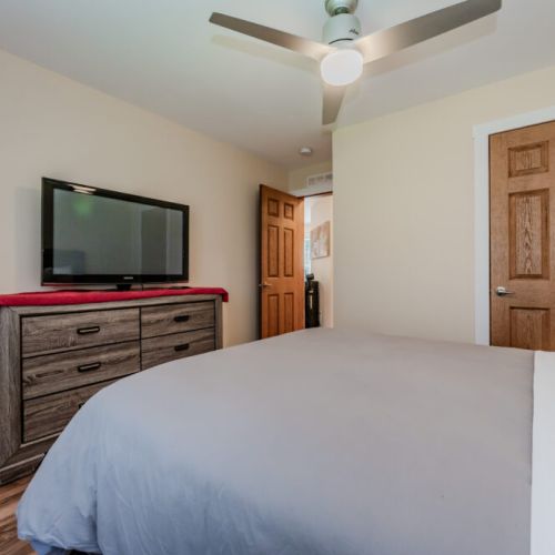 Relax and unwind in this cozy bedroom, featuring a soft bed, TV for late-night viewing, and plenty of storage space for your belongings.