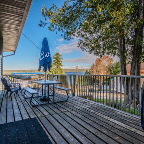 Enjoy stunning views of the lake from the cabin’s deck, complete with seating and a picnic table under a blue umbrella.